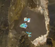 Satellite view of a vast brown salt basin bordered by mountains, with a cluster of brilliant turquoise and white evaporation ponds near its center.
